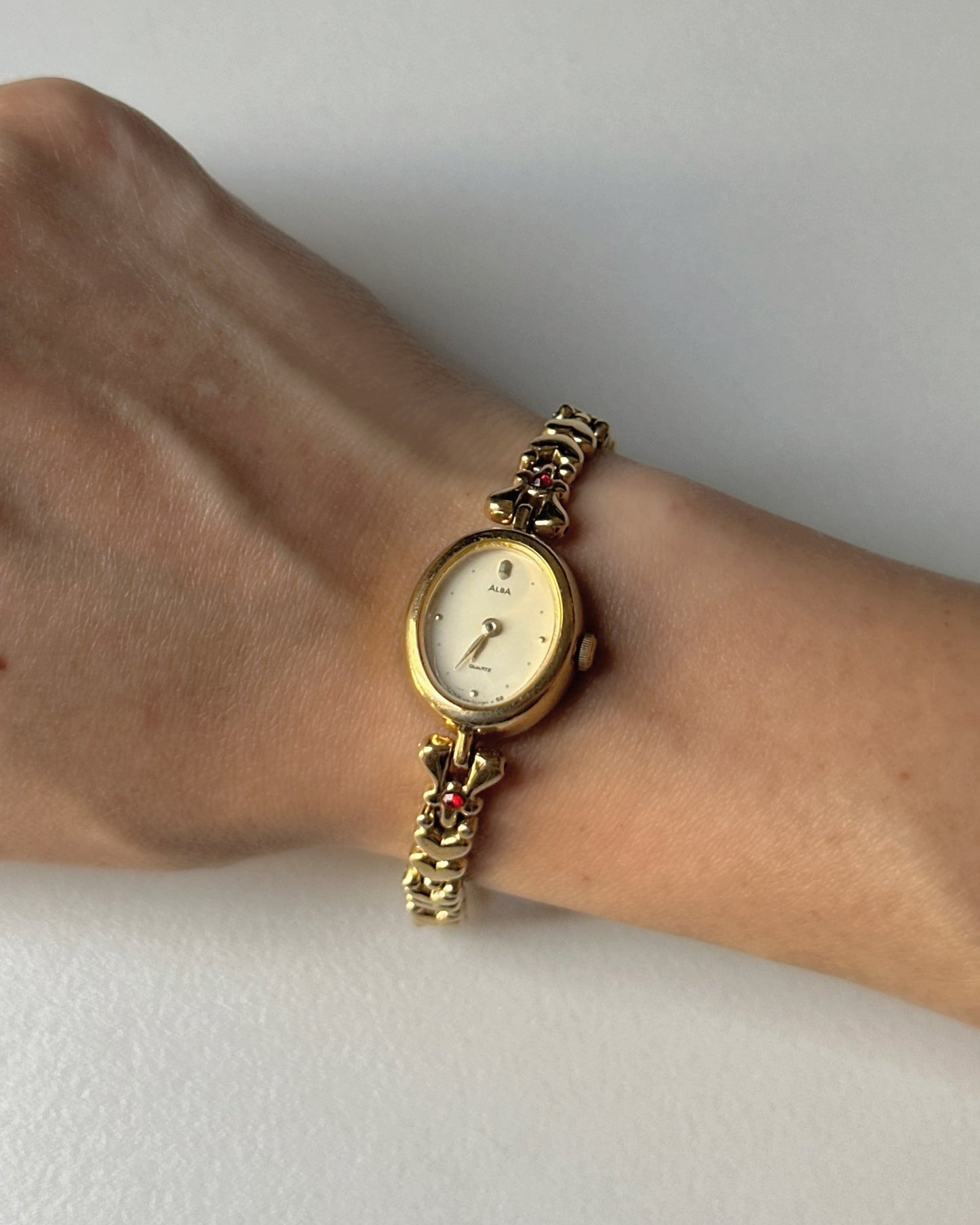 Dainty Alba Gold-Tone Bracelet Watch with Red Gem Accents