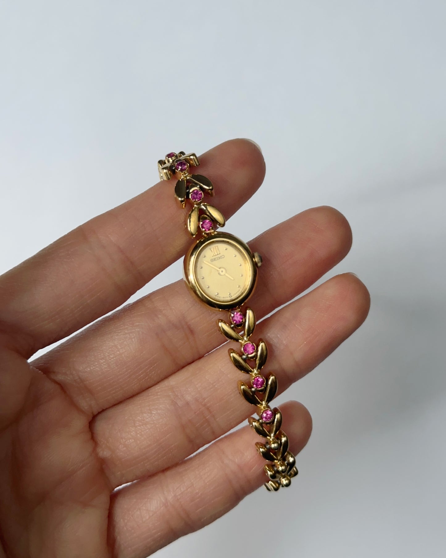 Seiko gold tone pink gem watch